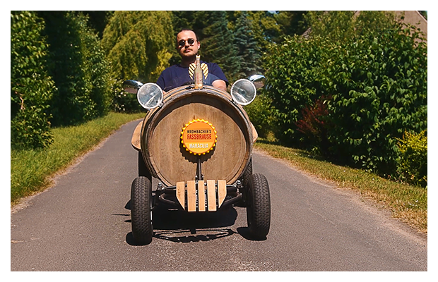 Fassbrause Mobil fährt mit Mann am Steuer über eine Straße