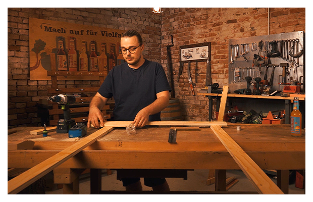 Ein Mann baut einen Holzrahmen.