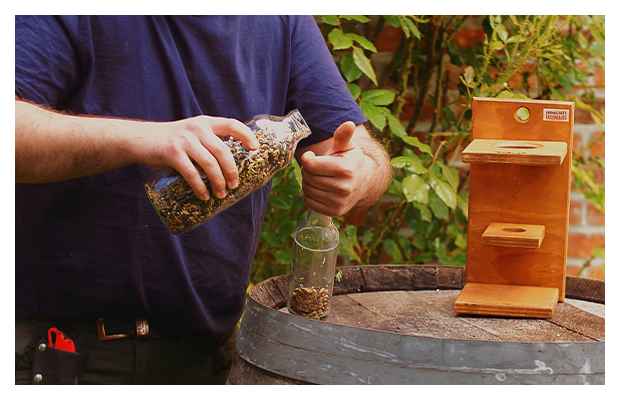 Vogelfutter werden in eine Glasflasche gefüllt.
