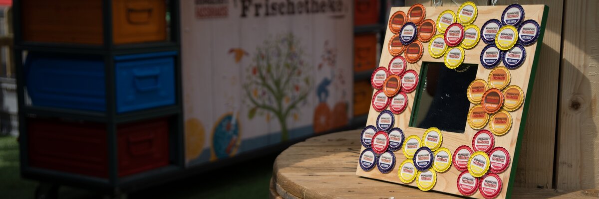 Blumen aus Kronkorken auf einem Holzbrett