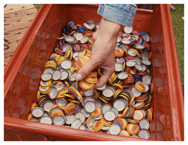 Kronkorken in roter Kiste