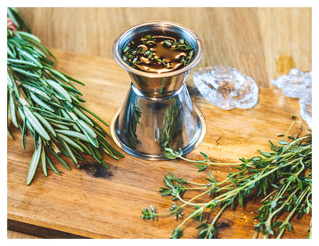 Kräuterzucker in Behälter mit Rosmarin