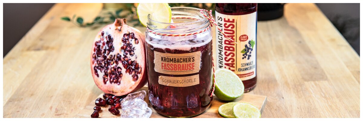 Fassbrause Schwarze Johannisbeere als Cocktail mit Granatapfel und Text: Schauerschorle